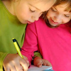 2 girls working together in a workbook